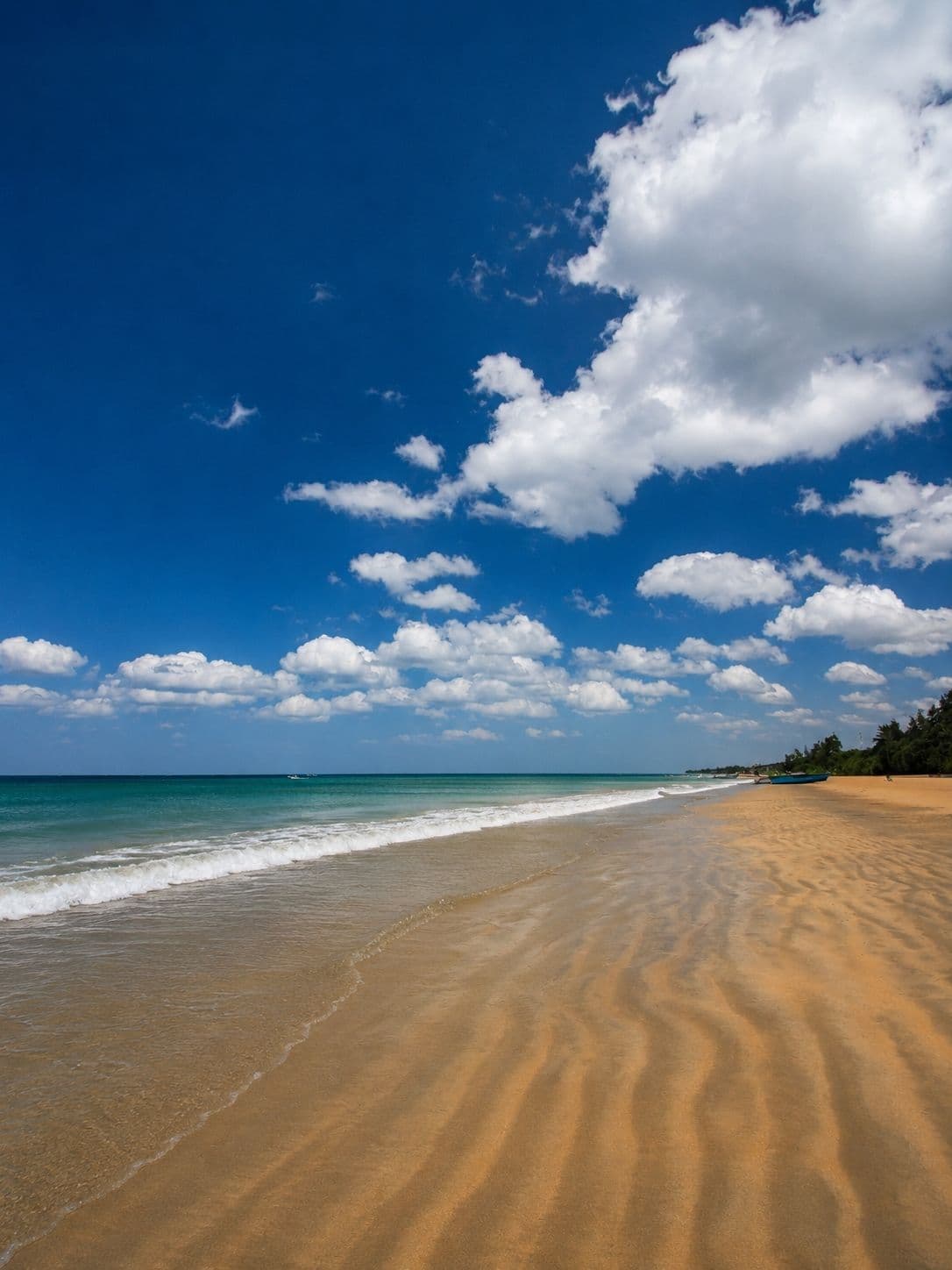 Pale empty sand and calm water at Nilaveli beach in the eastern dry season
