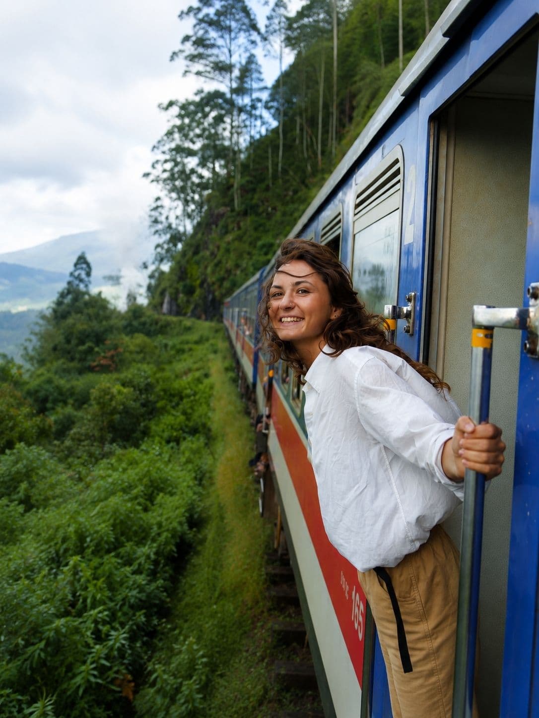 The blue train crossing a viaduct through tea terraces in the central highlands